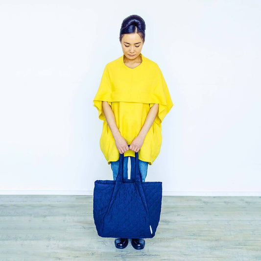Woman wearing The Costume Room sunshine yellow Linen Cocoon Top with navy blue Linen Quilted Bag