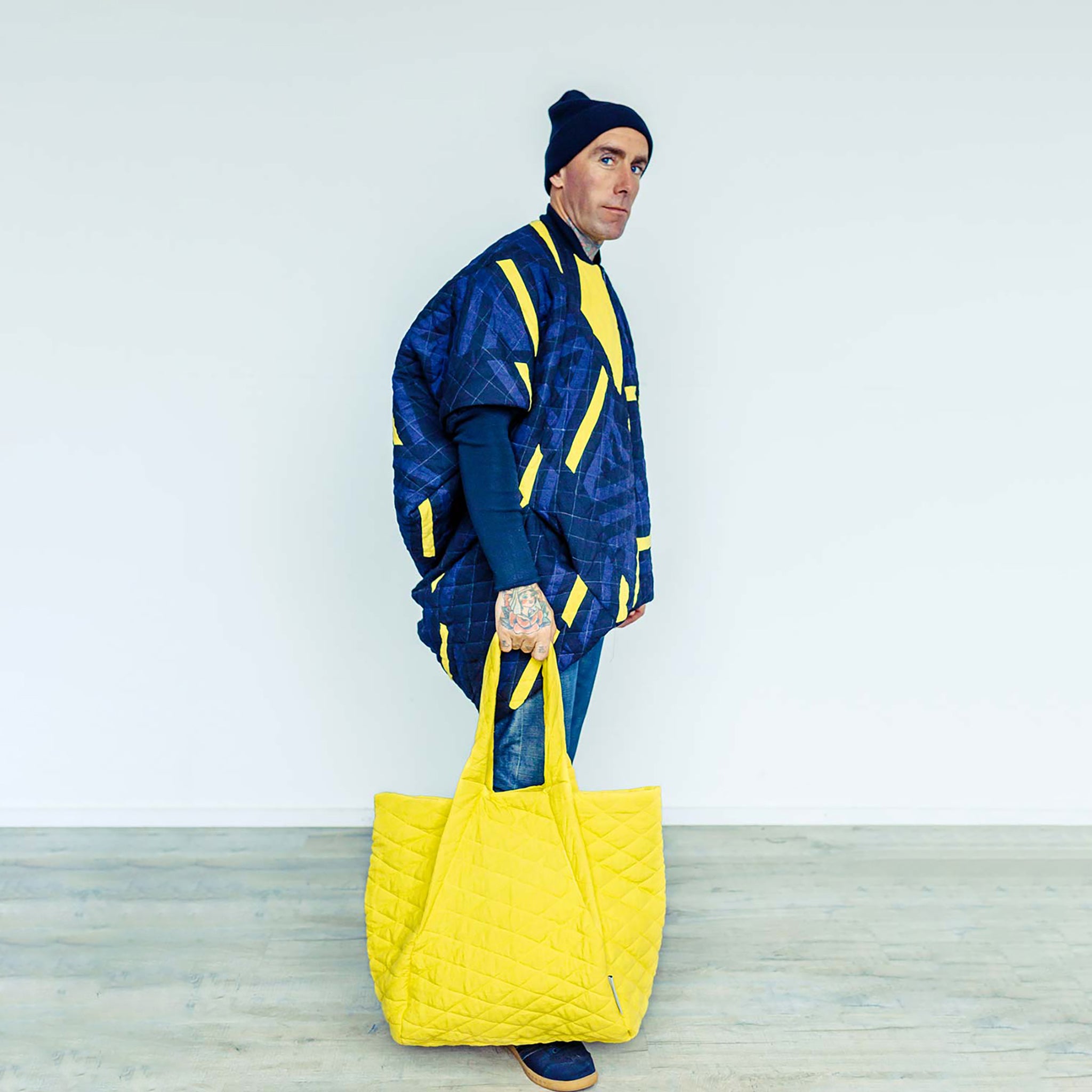 Man wearing The Costume Room Linen Patchwork Cocoon Coat with sunshine yellow Linen Quilted Bag