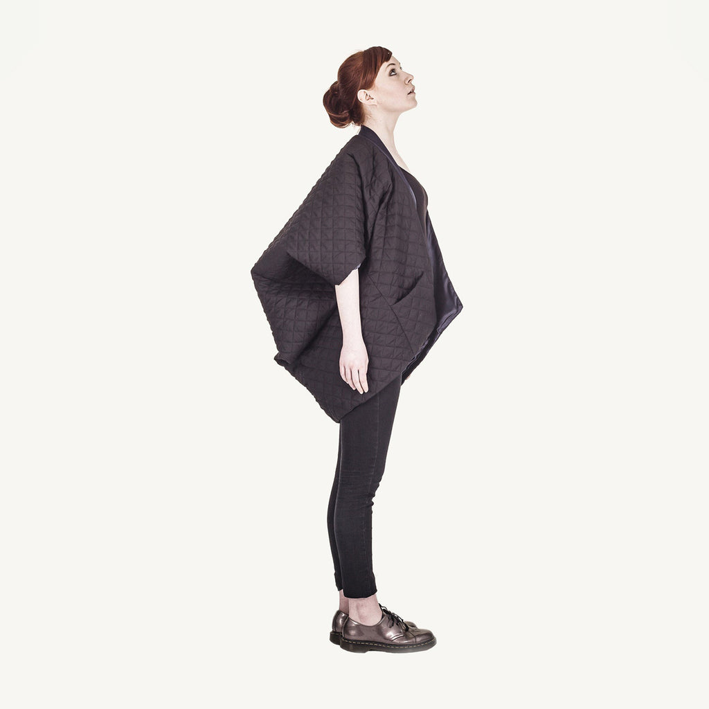 Woman wearing The Costume Room The Gar coat kimono style black linen quilted coat with navy collar