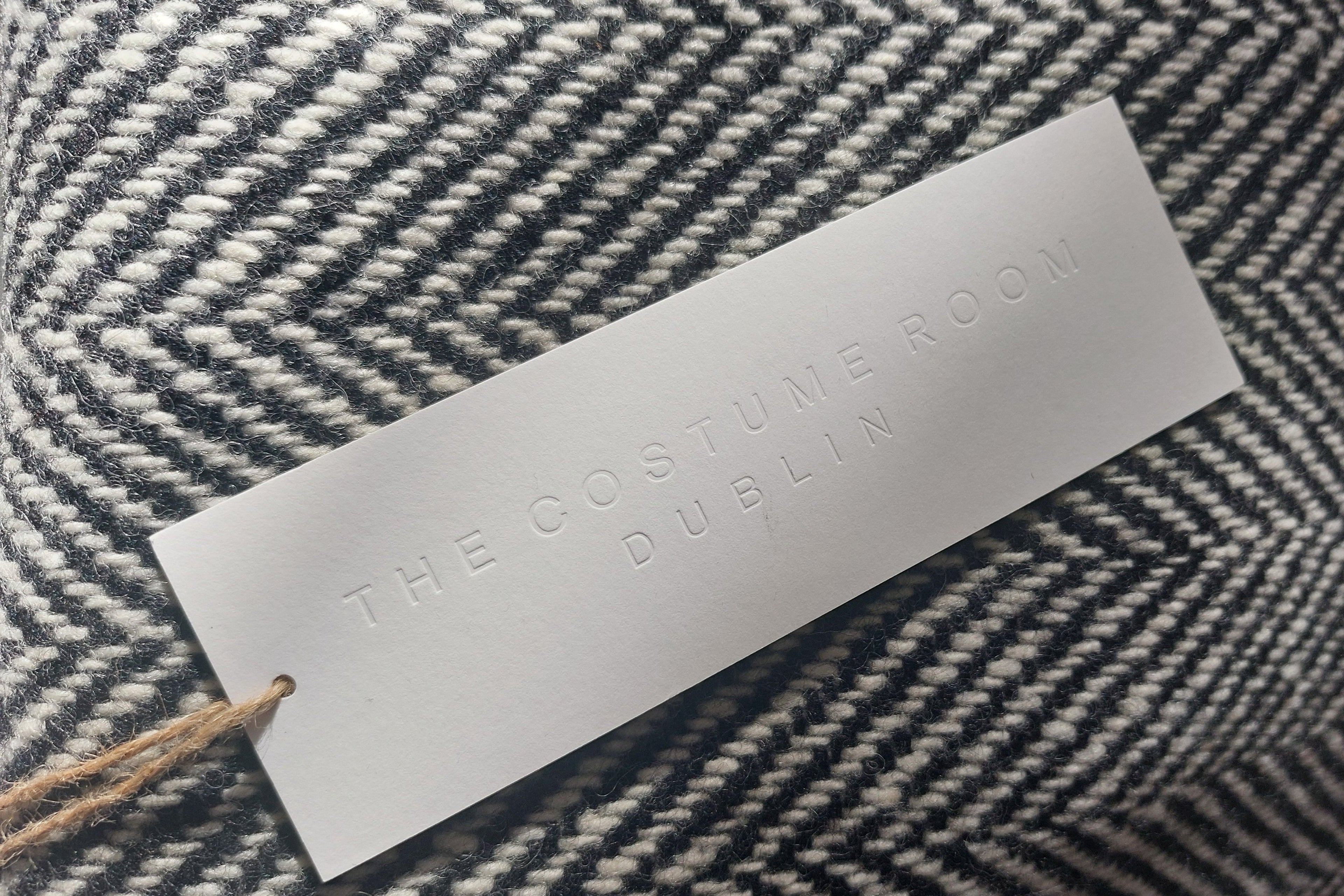 Label with 'The Costume Room Dublin' on a herringbone fabric background