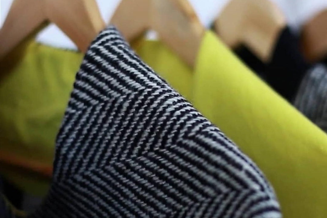 Handwoven donegal tweed witth yellow 100% pure Irish Linen on wooden hangers on a rail
