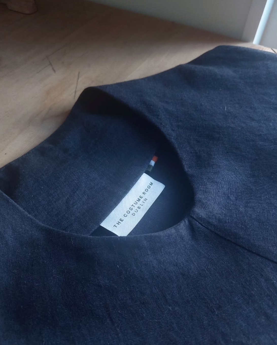 Close-up of navy Irish linen piece with The Costume Room label