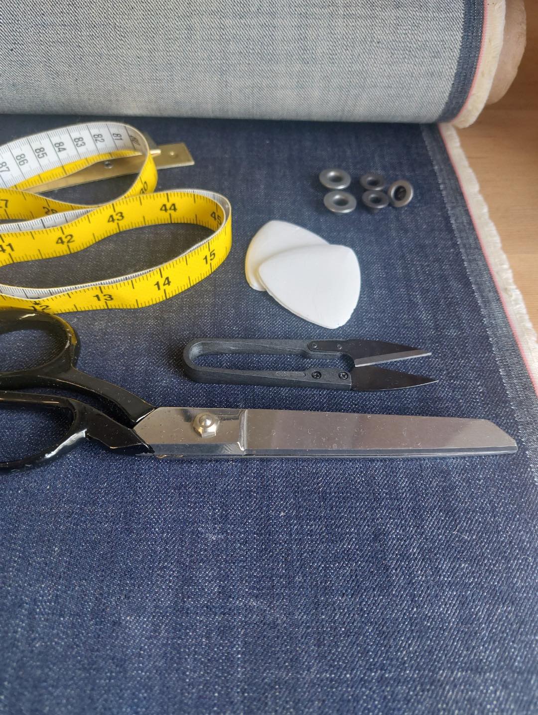 Studio tools resting on raw organic indigo denim.