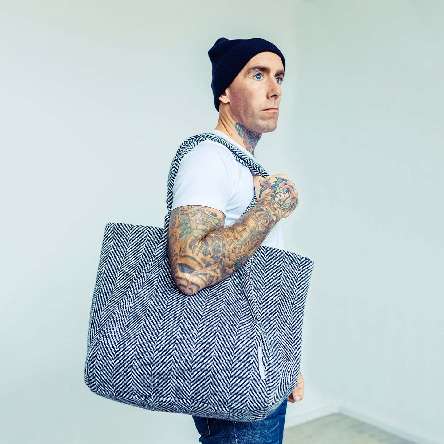 Man wearing The Costume Room monochrome herringbone Handwoven Donegal Tweed Bag on his shoulder