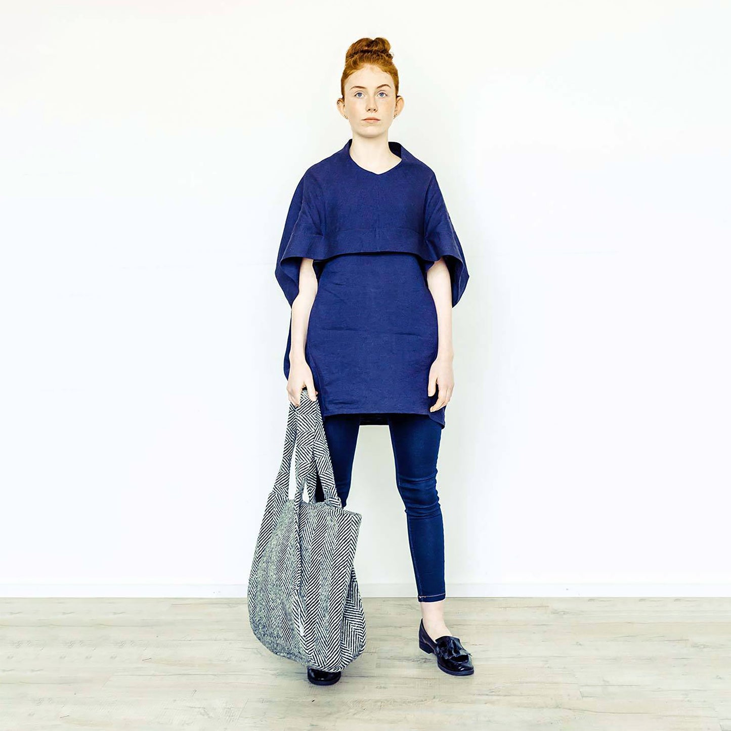 Woman wearing The Costume Room navy linen top and monochrome herringbone Handwoven Donegal Tweed Bag