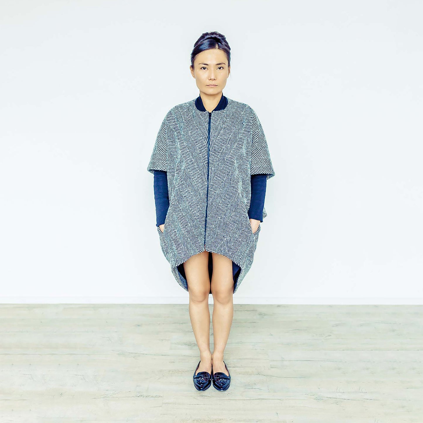 Woman wearing The Costume Room monochrome herringbone Handwoven Donegal Tweed Cocoon Coat