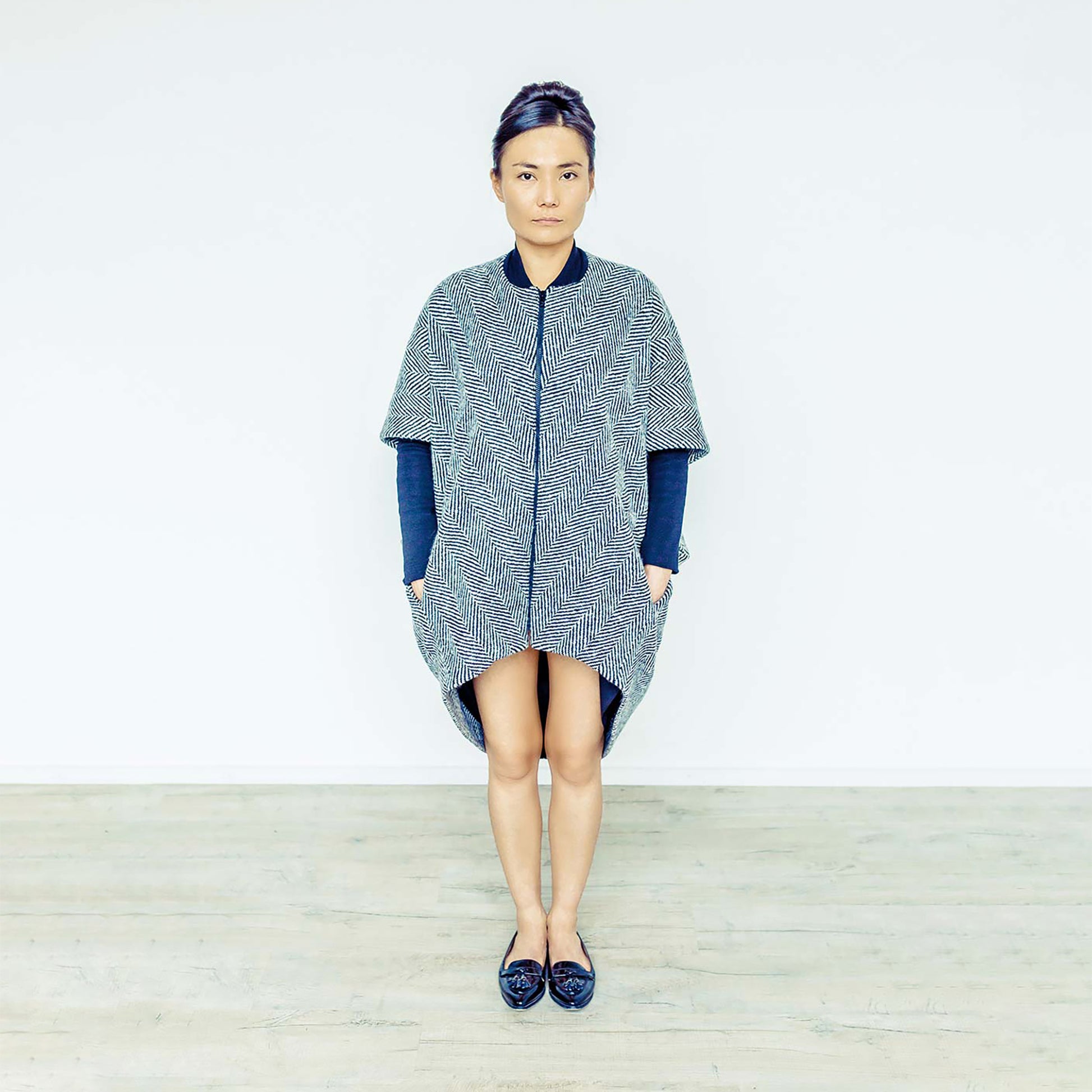 Woman wearing The Costume Room monochrome herringbone Handwoven Donegal Tweed Cocoon Coat