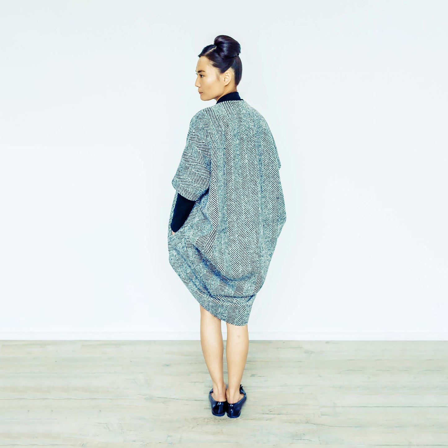 Woman wearing The Costume Room monochrome herringbone Handwoven Donegal Tweed Cocoon Coat