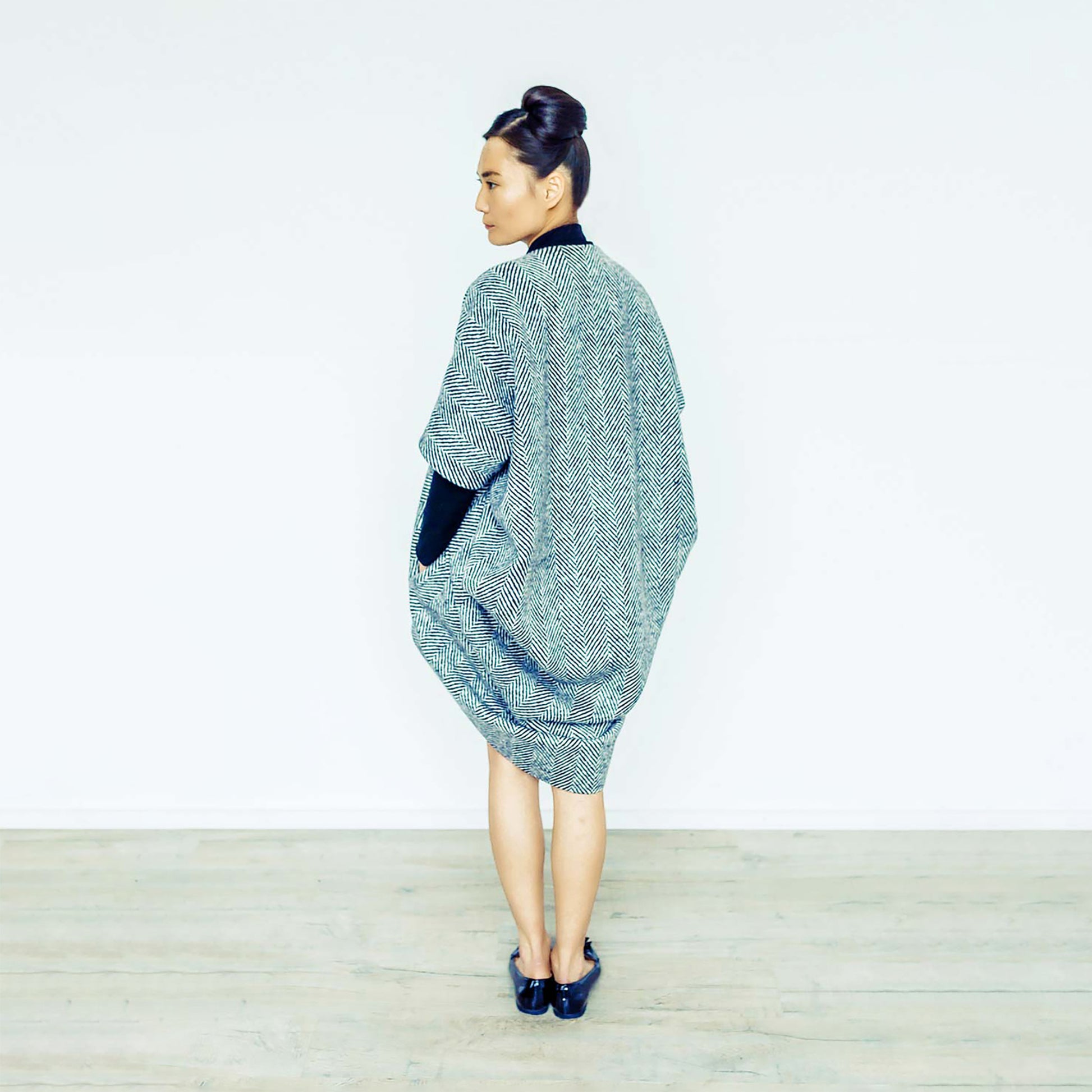 Woman wearing The Costume Room monochrome herringbone Handwoven Donegal Tweed Cocoon Coat
