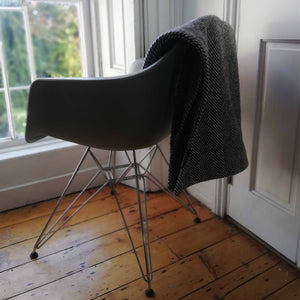 The Costume Room monochrome herringbone Handwoven Donegal Tweed Throw on a chair by a window