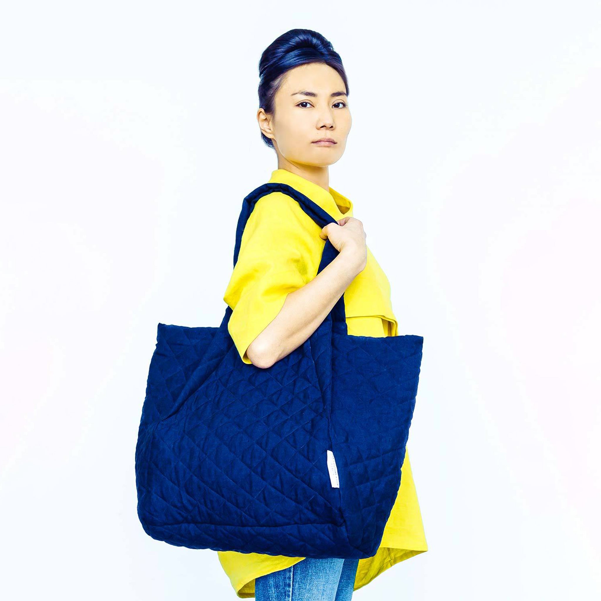 Woman wearing The Costume Room yellow Linen Top with navy blue Linen Quilted Bag on her shoulder
