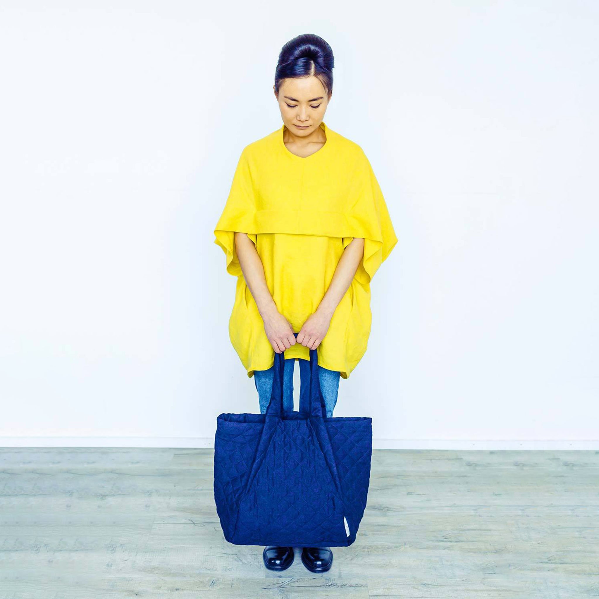 Woman wearing The Costume Room sunshine yellow Linen Cocoon Top with navy blue Linen Quilted Bag