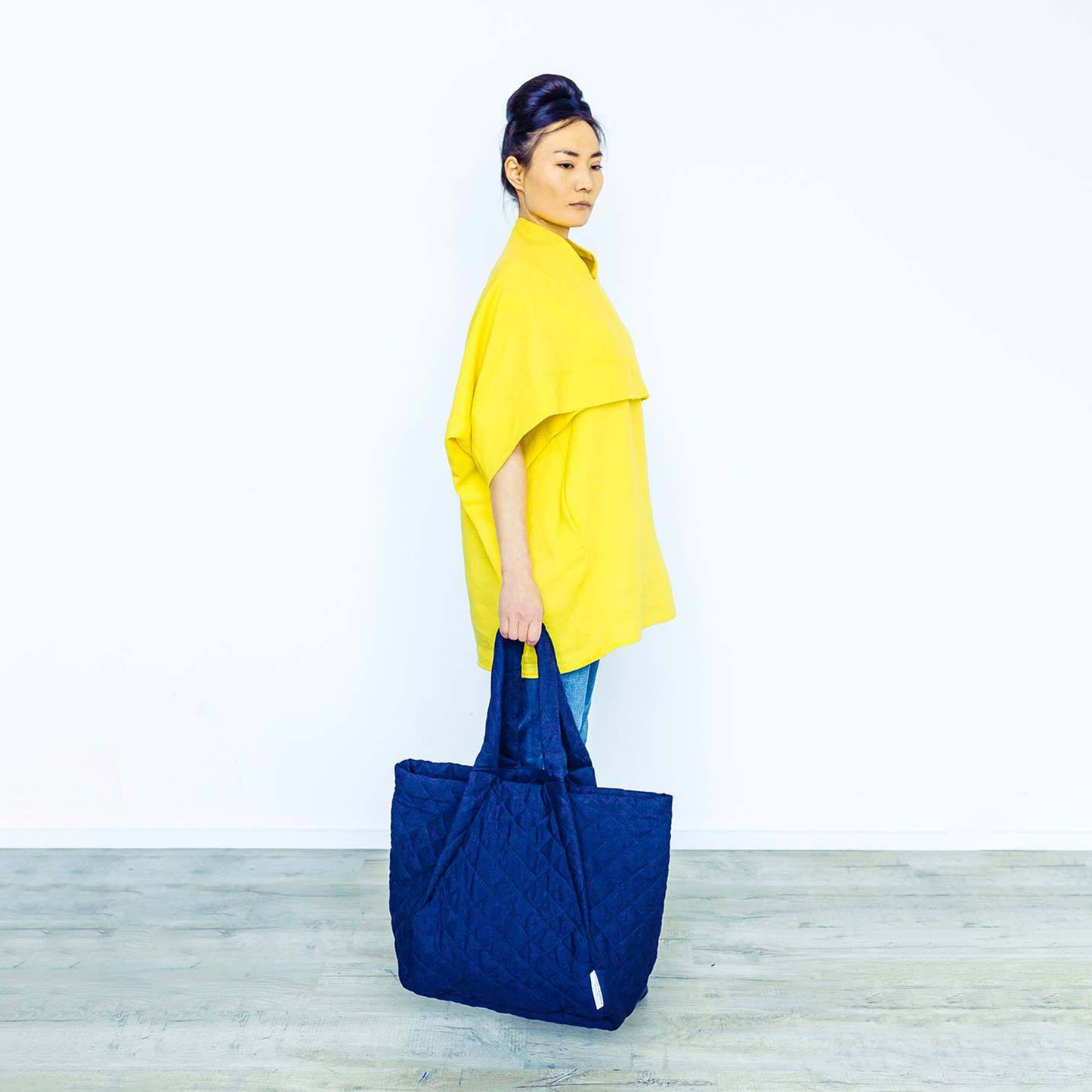 Woman wearing The Costume Room sunshine yellow Linen Cocoon Top with navy blue Linen Quilted Bag