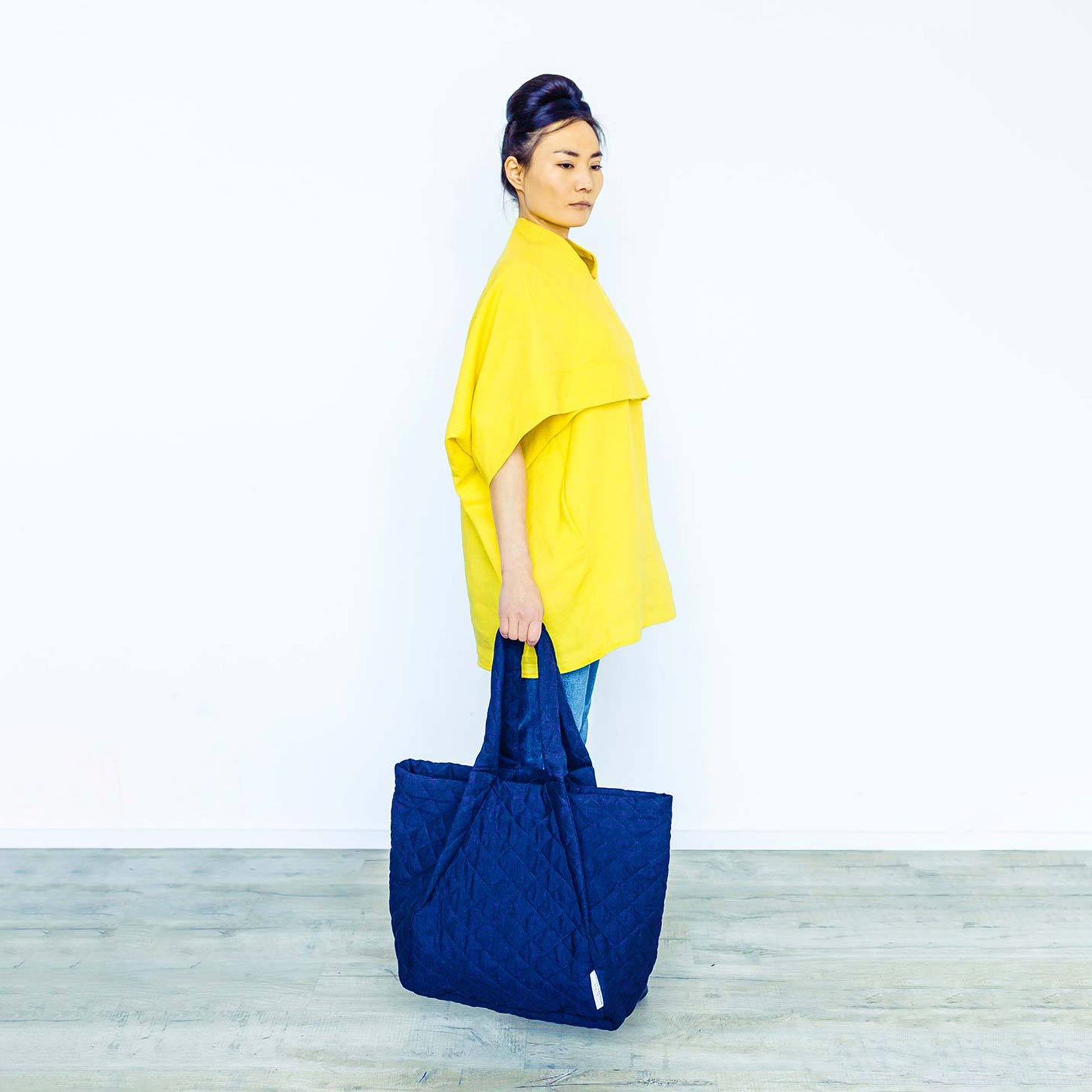Woman wearing The Costume Room sunshine yellow Linen Cocoon Top with navy blue Linen Quilted Bag