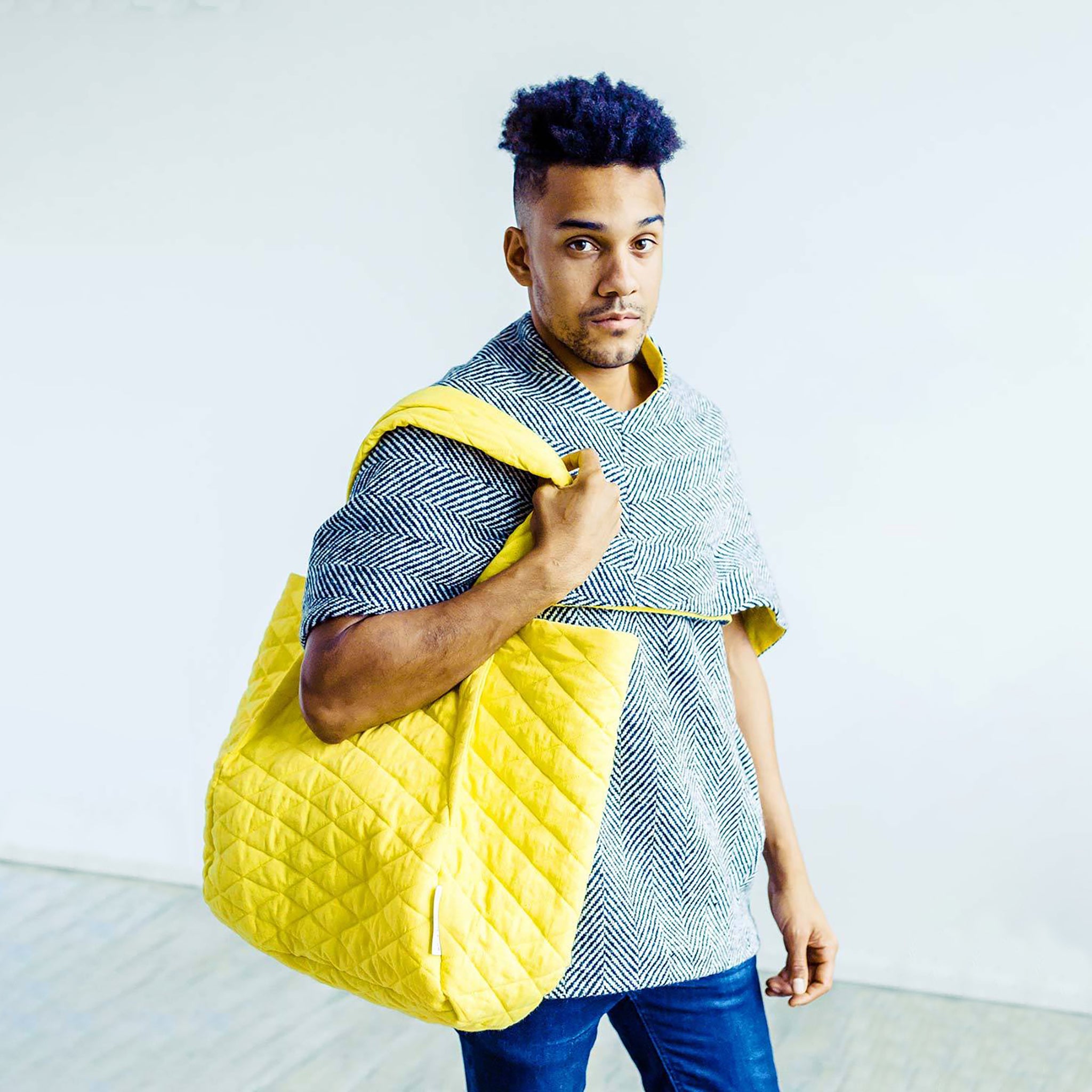 Man wearing The Costume Room Handwoven Donegal Tweed Top and yellow Linen Quilted Bag on shoulder