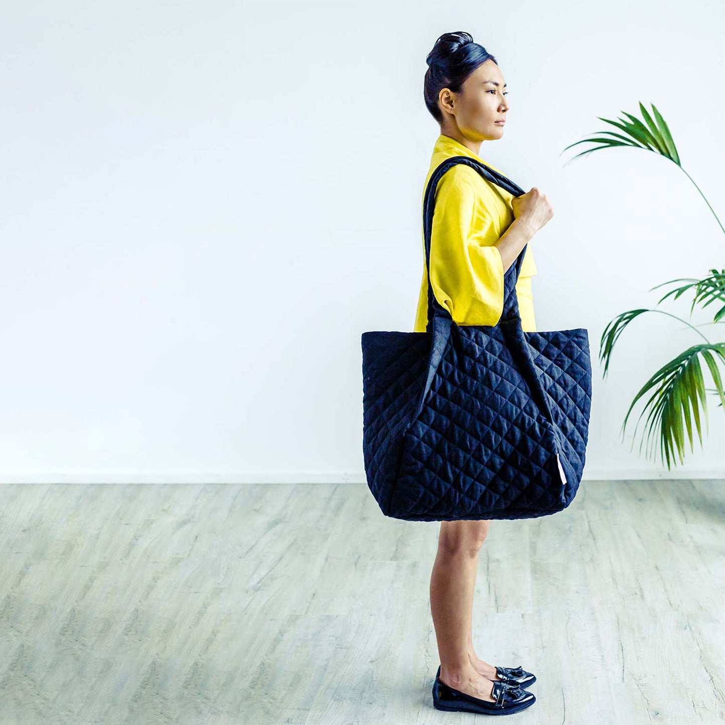 Woman in Dublin wearing The Costume Room yellow Linen Dress with Black Linen Quilted Crossbody Bag