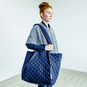 Woman wearing The Costume Room Handwoven Donegal Tweed Coat with Black Linen Quilted Crossbody Bag