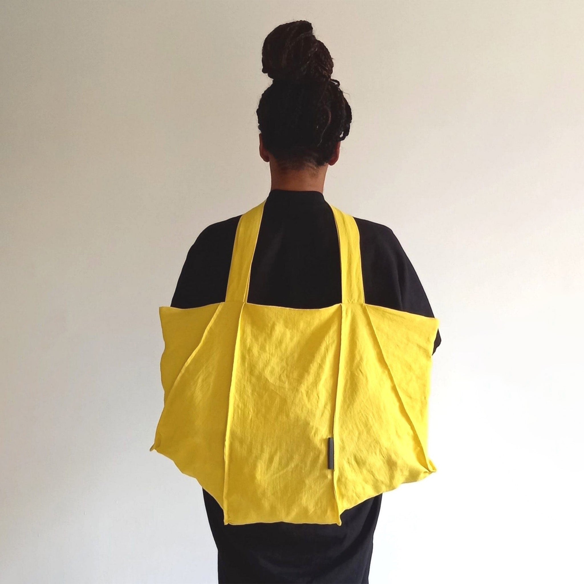 Man wearing The Costume Room sunshine yellow Linen Tote Bag on his back
