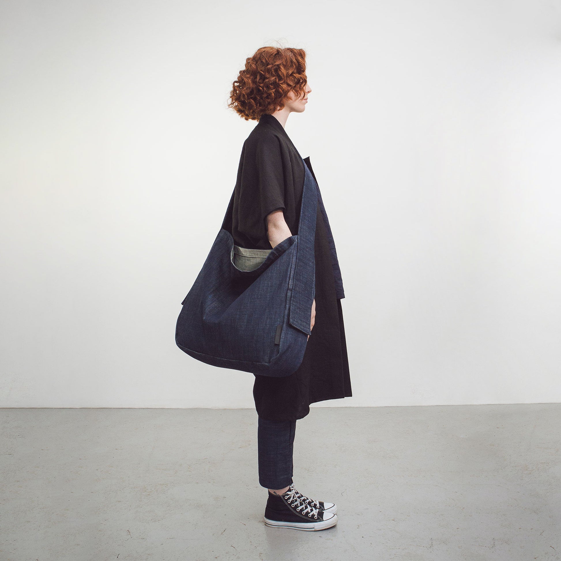Woman with red hair wearing The Costume Room Raw Organic Denim Crossbody bag