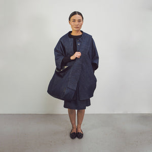 Woman wearing The Costume Room Raw Organic Denim Crossbody bag with Linen top and skirt