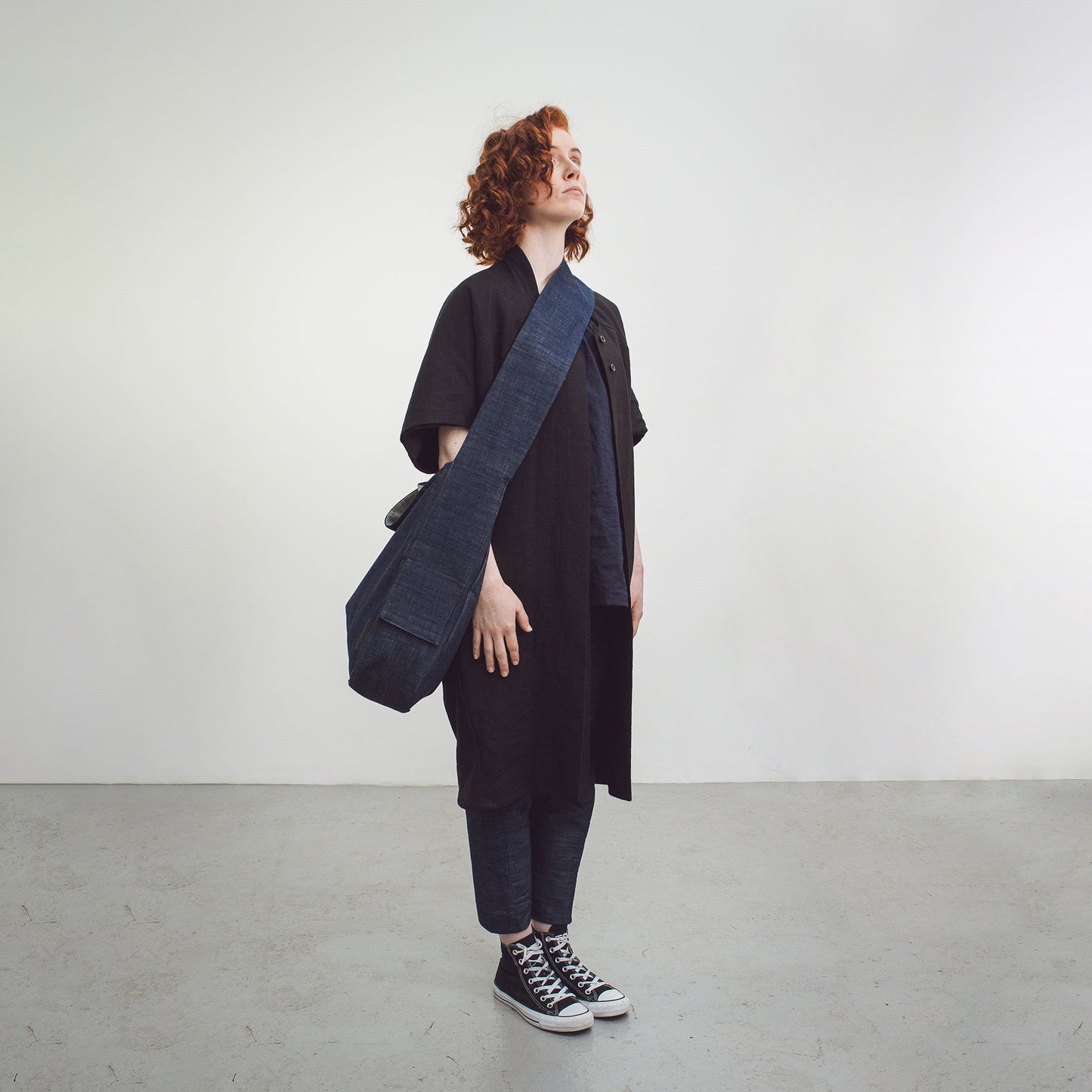 Woman with red hair wearing The Costume Room Raw Organic Denim Crossbody bag