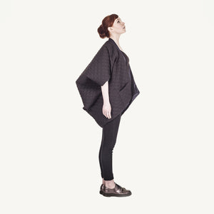 Woman wearing The Costume Room The Gar coat kimono style black linen quilted coat with navy collar