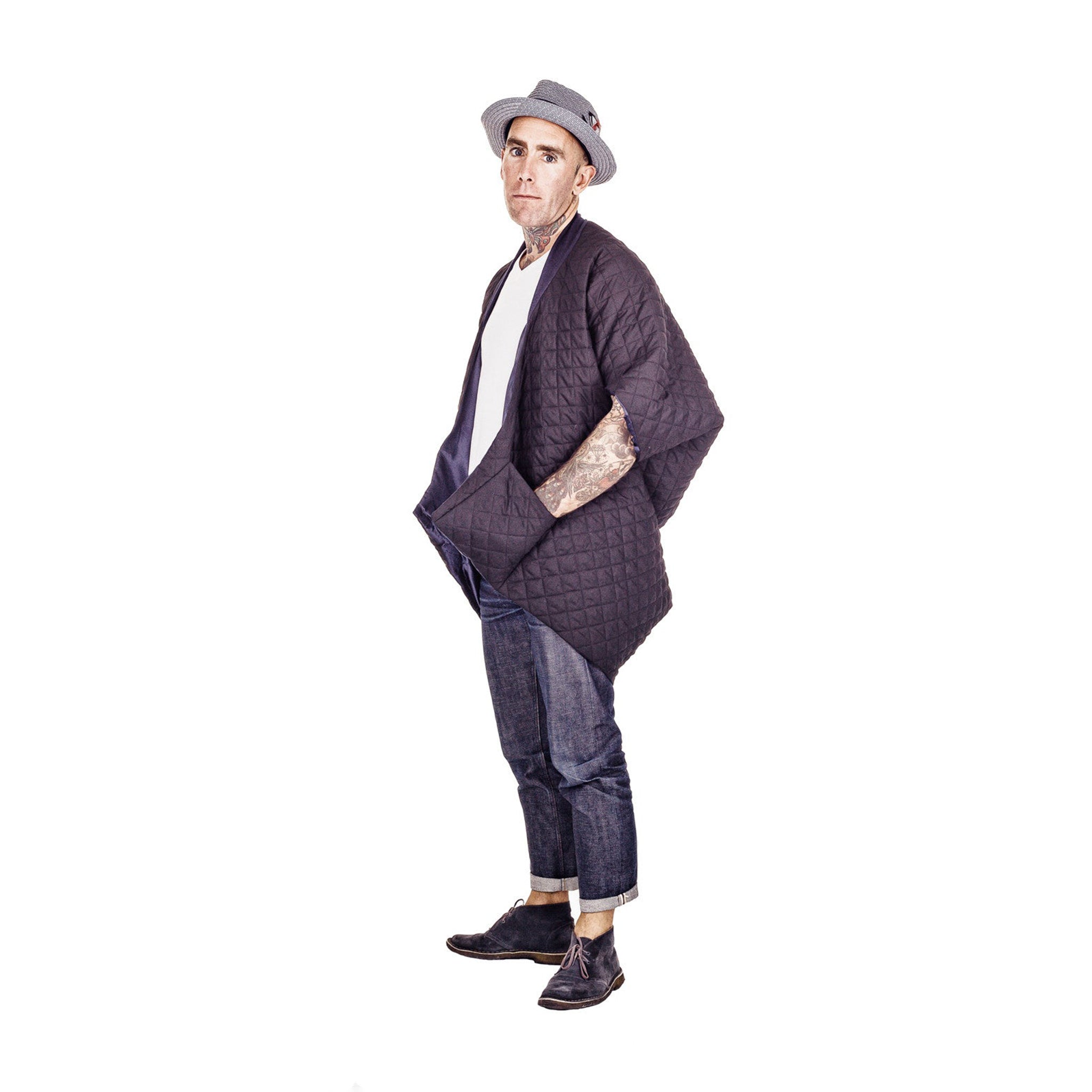 Man wearing The Costume Room The Gar coat kimono style black linen quilted coat with navy collar