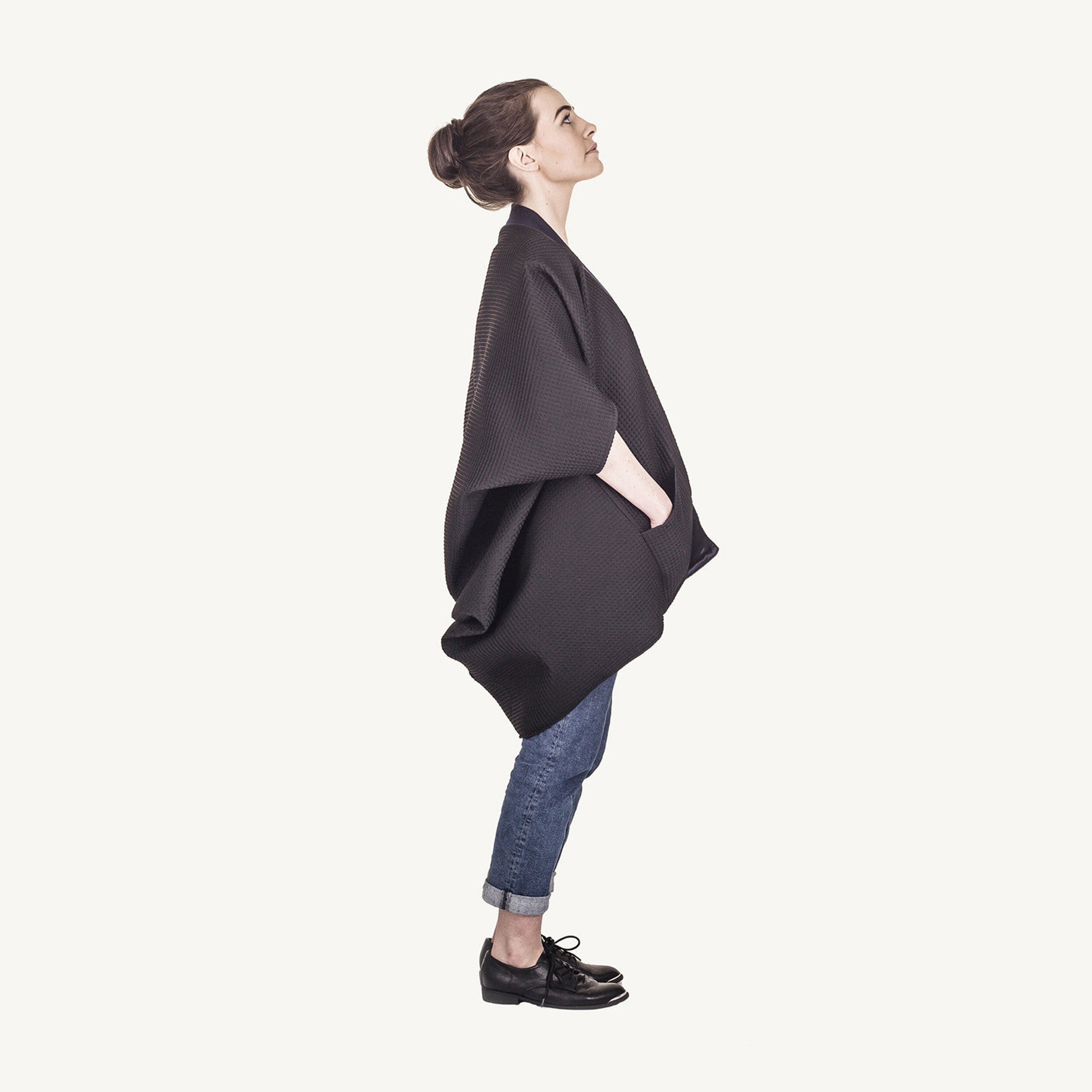 Woman wearing The Costume Room The Iris kimono style black waffle weave coat with navy blue collar